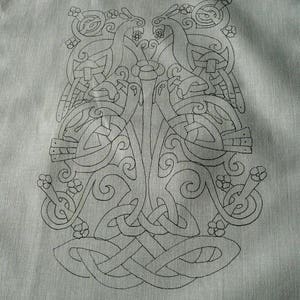 May include: A black and white line drawing of a stylised tree with two birds on branches. The tree is surrounded by a decorative border of leaves and flowers.
