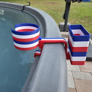 May include: A red, white, and blue striped cup holder and a matching rectangular container attached to a gray edge. The cup holder is designed to hold a beverage, and the container is designed to hold other items.
