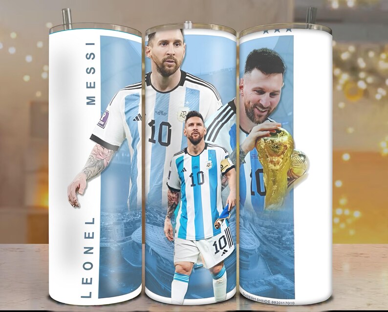 May include: A white stainless steel tumbler featuring images of Lionel Messi in his Argentina soccer uniform. The tumbler has a silver straw and the name "LEONEL MESSI" printed vertically. The design includes the number 10 and a gold trophy.