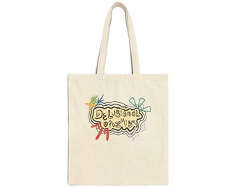 May include: Cream-colored tote bag with a whimsical design. The bag features the words "Delusional Optimism" in a playful, colorful font, surrounded by doodle-like illustrations. The bag has two long handles for carrying.