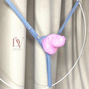 May include: Light blue lingerie with a pink accent. The lingerie features adjustable straps and a delicate design. The image includes the logo of a leather store.