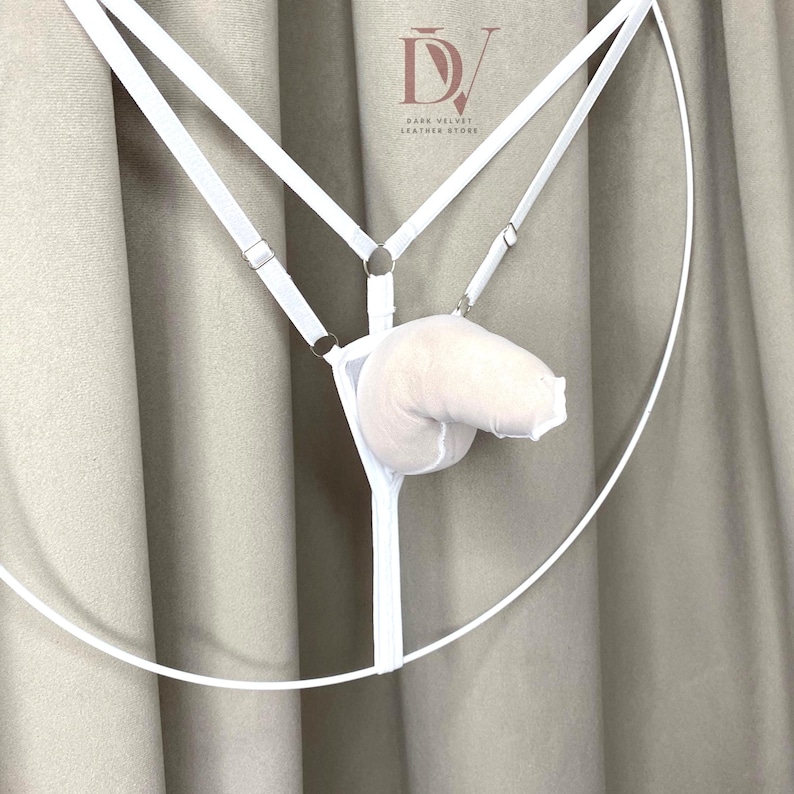 Puede incluir: Conjunto de lencer&iacute;a blanco con dise&ntilde;o de arn&eacute;s, correas ajustables y una bolsa suave y acolchada. El conjunto incluye un marco circular y se muestra sobre un fondo neutro. El logotipo de Dark Velvet Leather Store es visible.