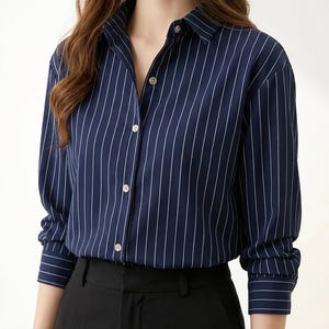 May include: A navy blue shirt with vertical white stripes, featuring a classic collar and buttoned cuffs. The long-sleeved shirt is paired with black trousers. A versatile and stylish garment.