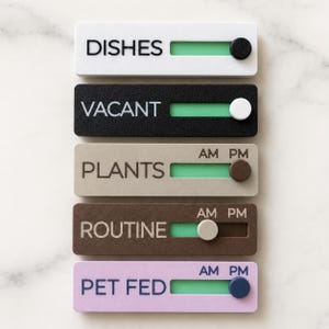 May include: Five rectangular sliding task trackers with labels DISHES, VACANT, PLANTS, ROUTINE, and PET FED. Each tracker features a horizontal slot with a green background and a movable circular slider button in various colours to indicate status.