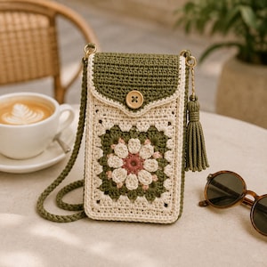 Può includere: Una borsa a tracolla rettangolare all'uncinetto con una patta verde oliva scuro e una chiusura con bottone in legno. Il corpo presenta un motivo granny square color crema con un fiore centrale nelle tonalità del rosa, crema e verde oliva.