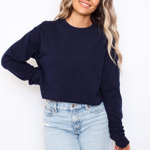 Puede incluir: Una camiseta de manga larga azul marino con cuello redondo y corte cropped. Las mangas son largas y ajustadas. La camiseta est&aacute; hecha de un material suave. Una camiseta de color s&oacute;lido adecuada para ropa casual.