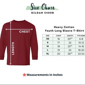 Puede incluir: Una camiseta de manga larga juvenil de color granate con una tabla de tallas. La tabla muestra medidas de pecho de 40,6 a 50,8 cm y largos de 52,1 a 67,3 cm. La camiseta es de algod&oacute;n grueso y est&aacute; disponible en tallas XS a XL.