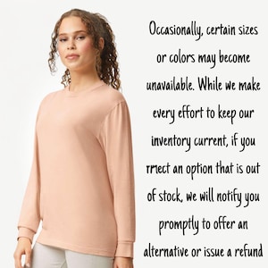 May include: A long-sleeved, peach-coloured shirt. The shirt has a crew neck and ribbed cuffs. Text on the right side of the image reads: "Occasionally, certain sizes or colours may become unavailable..."