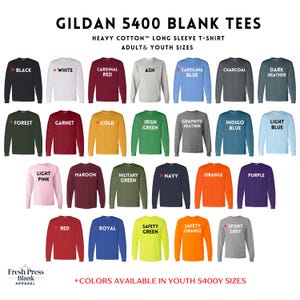 Puede incluir: Una exhibici&oacute;n de camisetas de manga larga Gildan 5400 en varios colores, incluyendo negro, blanco y rojo. Las camisetas son de algod&oacute;n pesado y est&aacute;n disponibles en tallas para adultos y j&oacute;venes. El texto "GILDAN 5400 BLANK TEES" est&aacute; en la parte superior.