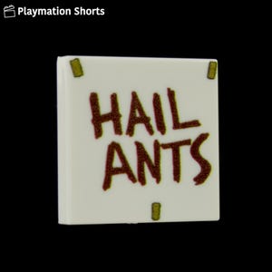 May include: A white square tile with the words "HAIL ANTS" in dark red, stylized lettering. The tile has four small, rectangular green accents, one in each corner. The background is black.