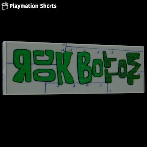May include: A rectangular tile with the words "ROCK BOTTOM" in bright green, stylized lettering. The tile has a light gray background with a grid pattern and small silver rivets. The words are outlined in a darker green.