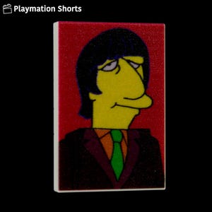 May include: A rectangular tile featuring a cartoon character with yellow skin, black hair, and a green tie. The character is dressed in a dark suit with an orange shirt. The background is red, and the tile has a white border. The text "Playmation Shorts" is in the top left corner.