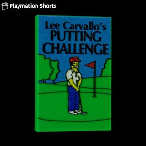 May include: A green rectangular object with the text "Lee Carvallo's PUTTING CHALLENGE" on a blue background. The image depicts a cartoon golfer on a green golf course with a red flag. The object is a Playmation Shorts product.