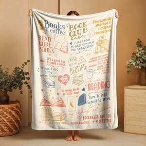May include: Cream-colored throw blanket with a book-themed design. The blanket features various illustrations of books, coffee cups, and text such as "Books & Coffee" and "Read More Books". The blanket is a cozy accessory for book lovers.