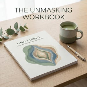 May include: A workbook titled "The Unmasking Workbook" with the subtitle "A Guide to Rediscovering Your Autistic Self." The cover features an abstract design in shades of blue, green, and beige. A mug of tea and a pen rest on the wooden surface.