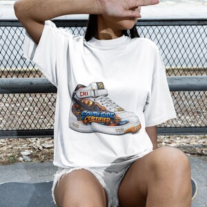 Puede incluir: Camiseta blanca con un gráfico colorido de una zapatilla deportiva con el texto "South Side Certified" y "CHI". El diseño del zapato incluye los números "312" y "773". La persona lleva un gorro oscuro.