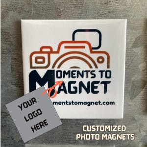 Puede incluir: Imán cuadrado blanco con un logotipo de cámara y el texto "Moments to Magnet". Incluye un cuadrado gris con "Your Logo Here". El texto inferior dice "Imanes de fotos personalizados".