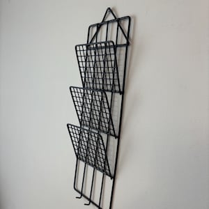 Puede incluir: Una taza de cerámica blanca con un asa negra y el texto "But First, Coffee" en negro, con una fuente de estilo manuscrito. La taza está sobre una superficie blanca.