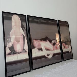 May include: Three framed prints displaying ballet shoes on a piano. The images show pink ballet slippers with ribbons, set against a piano keyboard. The frames are black, creating a soft and elegant aesthetic.