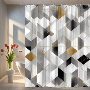 May include: A geometric shower curtain featuring a modern design with black, white, gray, and gold accents. The pattern consists of overlapping shapes and lines, creating a contemporary look. The curtain is hanging from a metal rod.