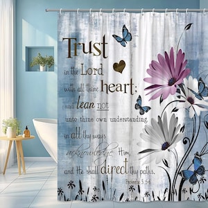 May include: A shower curtain with a blue and white background featuring the text "Trust in the Lord". It has floral and butterfly designs in shades of purple, white, and blue. The text is in a brown script font.