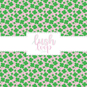 May include: A repeating pattern of green four-leaf clovers on a light pink background. A white rectangular label with dashed borders is centered, featuring the text lush loop studio in a pink and white cursive script font.