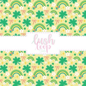 May include: A repeating pattern with rainbows, shamrocks, flowers, and bows on a pale yellow backdrop. The rainbows have blue, yellow, and green arches. The text "lush loop studio" is in the centre.