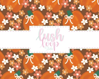 May include: A repeating pattern featuring orange pumpkins with white bows and green stems, alongside white and peach flowers, on a brown backdrop. The text "lush loop studio" is in the centre.