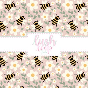 May include: A repeating pattern of black and yellow bees and white daisies with yellow centers on a light pink background. Green leaves and the text "Lush Loop Studio" are also present.
