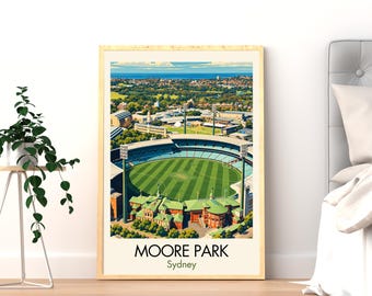 May include: A framed art print featuring an aerial view of the Sydney Cricket Ground in Moore Park, Sydney. The image displays a green oval stadium surrounded by trees and buildings, with the text MOORE PARK Sydney printed below.