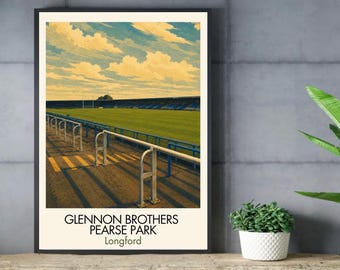 May include: A framed art print featuring a stadium scene with a green field, blue stands, and a yellow sky with clouds. The foreground shows metal railings on a paved area. The text at the bottom reads GLENNON BROTHERS PEARSE PARK Longford.