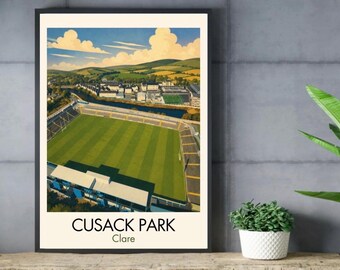 May include: A framed art print featuring an aerial illustration of Cusack Park in Clare. The image depicts a green sports field, stadium seating, and surrounding buildings under a blue sky with clouds. The text reads CUSACK PARK and Clare.
