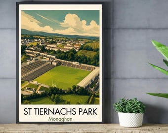 May include: A framed art print featuring an aerial illustration of St. Tiernachs Park in Monaghan. The image depicts a green sports field surrounded by stadium seating, trees, and a town under a blue sky with white clouds. Text reads St. Tiernachs Park Monaghan.