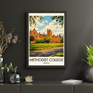 Pode incluir: Impressão artística emoldurada com o Methodist College em Belfast. A imagem mostra uma ilustração detalhada de um grande edifício de tijolos com várias torres e um gramado verde. O céu é azul com nuvens brancas. O texto "METHODIST COLLEGE Belfast" está na parte inferior.