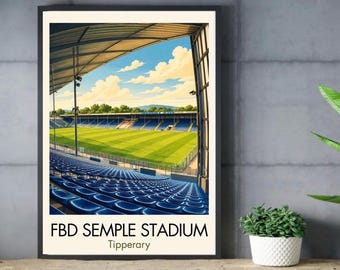 May include: A framed art print featuring a stadium interior with rows of blue seats, a bright green grass field, and a clear blue sky with white clouds. The text FBD SEMPLE STADIUM and Tipperary is printed in black at the bottom of the white border.