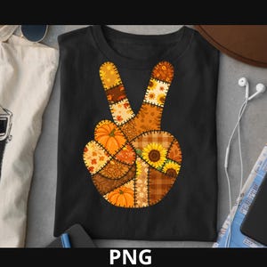 Könnte beinhalten: Schwarzes T-Shirt mit einem Peace-Zeichen-Design, das aus herbstlichen Patches besteht. Die Patches zeigen Kürbisse, Sonnenblumen und Blätter in Orange, Braun und Gelb. Das Wort "PNG" befindet sich am unteren Rand des Bildes.