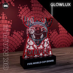 Puede incluir: Una pieza decorativa con forma de alce iluminada con LED rojo y negro con el texto "OK MAPLE" y "MAPLE" en la parte delantera. La base dice "FIFA WORLD CUP 2026". La palabra "GLOWLUX" también es visible.