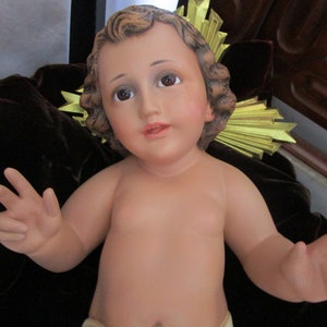Antiek beeldje van baby-baby kind Jezus met glazen ogen.  Vintage religieus standbeeld uit de jaren 1950.