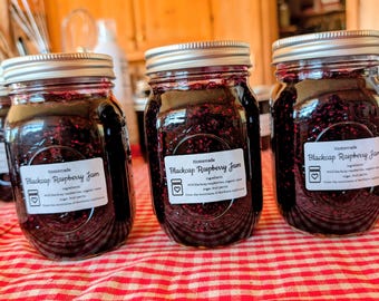 May include: Three glass jars filled with dark purple homemade blackcap raspberry jam, each featuring a white label that reads Homemade Blackcap Raspberry Jam, ingredients, wild blackcap raspberries, organic cane sugar, fruit pectin.