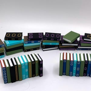 May include: Miniature books in various colors, including teal, green, and black, are arranged in stacks and rows. Some books have decorative patterns and the number "8" on their spines. The overall theme is a collection of small, decorative books.