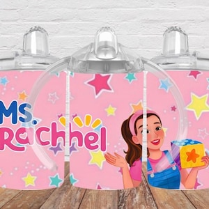 Puede incluir: Una taza de cer&aacute;mica blanca con asa negra y el texto "But First, Coffee" en negrita negra. La taza se encuentra sobre un fondo borroso, sugiriendo un ambiente acogedor.