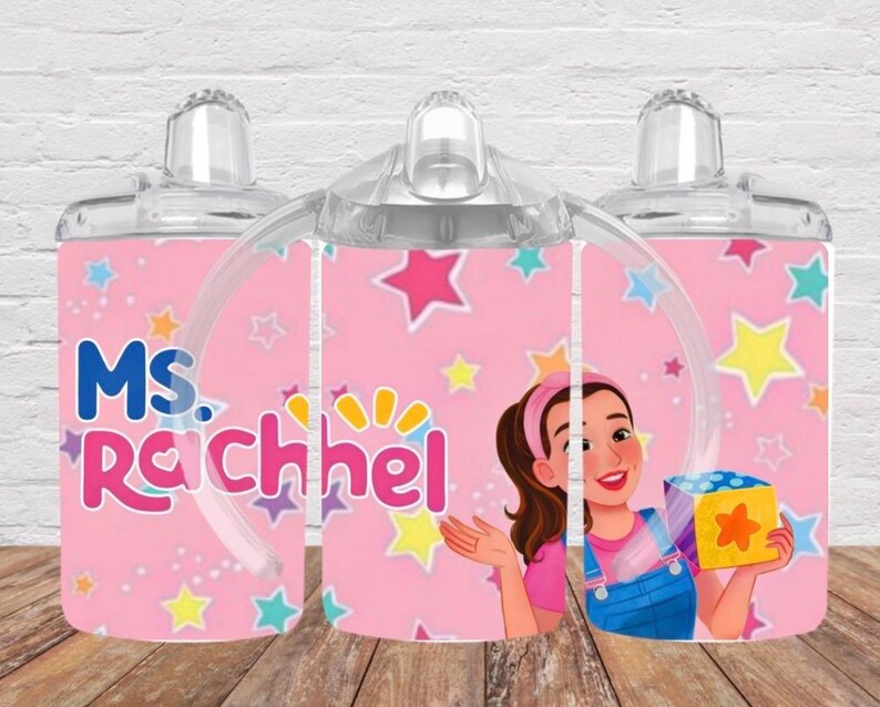 Puede incluir: Una taza de cer&aacute;mica blanca con asa negra y el texto "But First, Coffee" en negrita negra. La taza se encuentra sobre un fondo borroso, sugiriendo un ambiente acogedor.