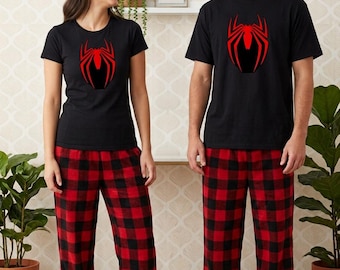 May include: Two matching sets of pajamas consisting of black short-sleeved t-shirts with a red spider graphic on the chest and red and black buffalo plaid flannel pants. The shirts feature a crew neckline and the pants have a loose fit.