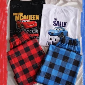 May include: A black t-shirt with a red car graphic and the text Lightning McQueen, a white t-shirt with a blue car graphic and the text I'm Sally, red and black plaid pajama pants, and blue and black plaid pajama pants with an elastic waistband.