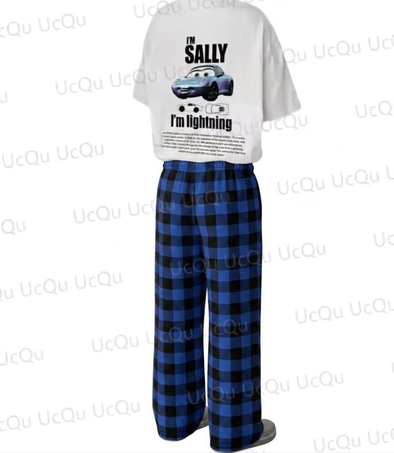 May include: A white short-sleeved t-shirt featuring a graphic of a blue car with the text I'M SALLY and I'M LIGHTNING, paired with blue and black plaid pajama pants. The shirt includes a small car illustration and a block of small printed text.
