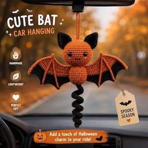 May include: A crocheted orange and black bat car hanging ornament with a spiral tail. The bat has black ears and wing tips. A beige tag attached to the wing reads SPOOKY SEASON with a bat icon and heart. Text on the image reads CUTE BAT CAR HANGING.