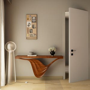 May include: A contemporary hallway scene with a floating wooden console table. The table has a distinctive wave design. A tall, clear glass lamp with a spherical top is on the left. A corkboard with postcards hangs on the wall. A black vase with flowers sits on the table.