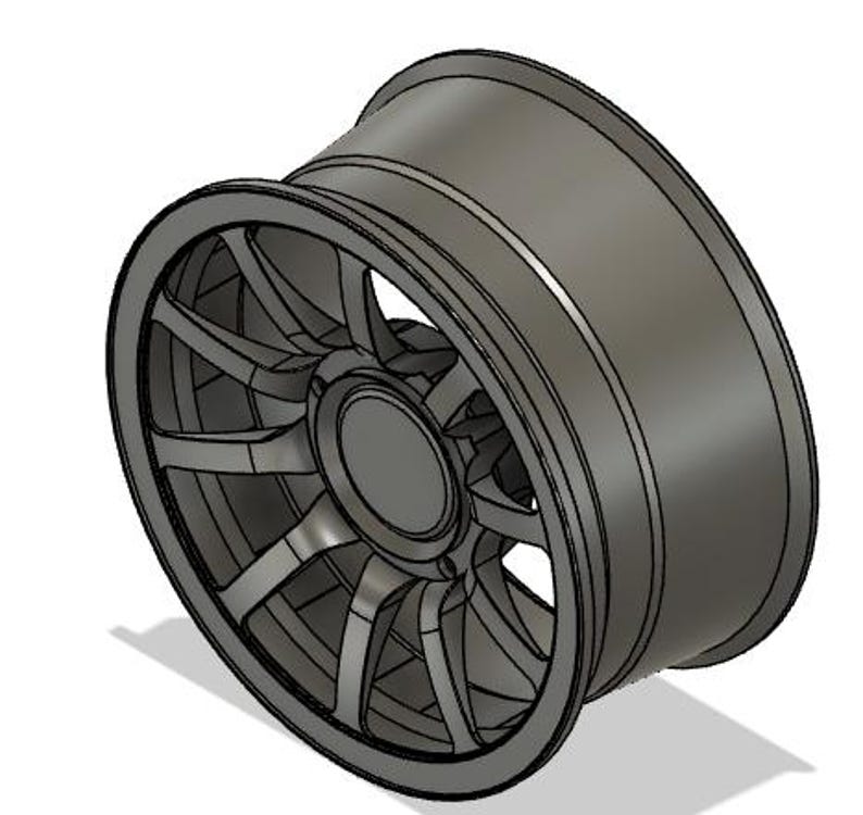 May include: A gray alloy wheel with a multi-spoke design. The wheel has a rounded outer rim and a central hub. The spokes are evenly spaced and connect the hub to the rim. The wheel is designed for a vehicle.