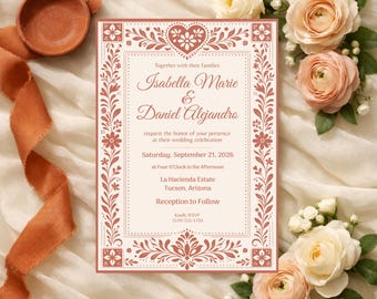 May include: A wedding invitation in pink and cream with floral patterns. The invitation features the names Isabella Marie & Daniel Alejandro, the wedding date, time, and venue. Roses and a terracotta ribbon surround the invitation. The invitation measures approximately 15 cm x 10 cm.