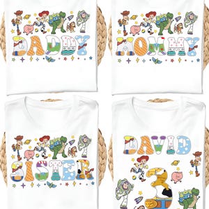 May include: Four white t-shirts with colorful graphics. Each shirt features a different name: "DADDY", "MOMMY", "SISTER", and "DAVID". The designs include cartoon characters and decorative elements.